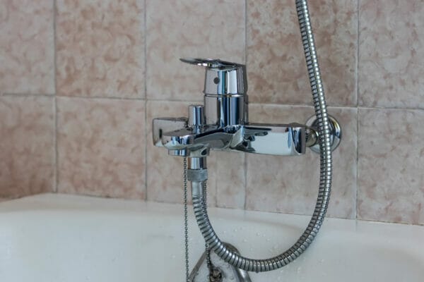 Water tap with a hose from the shower over the bath