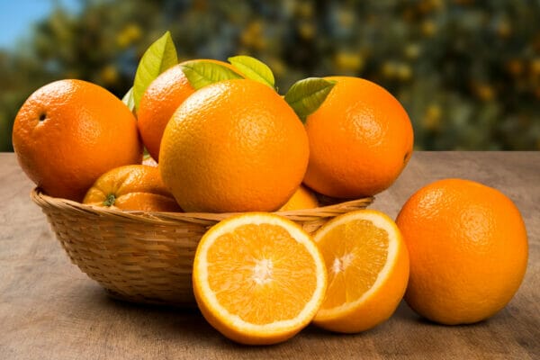Close up of some oranges in a basket over a wooden surface