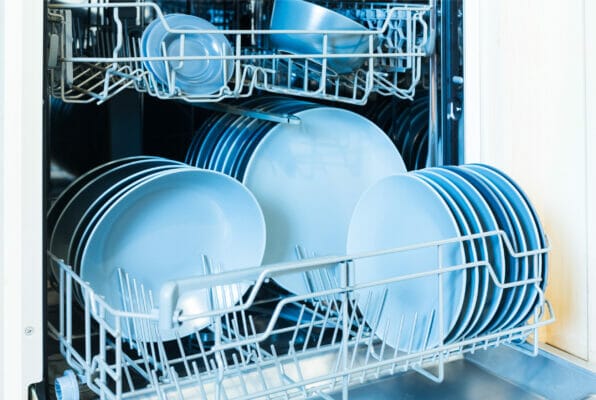 Open dishwasher with clean dishes after cleaning process