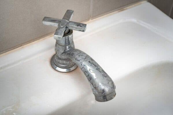 Dirty faucet with stain and limescale in bathroom